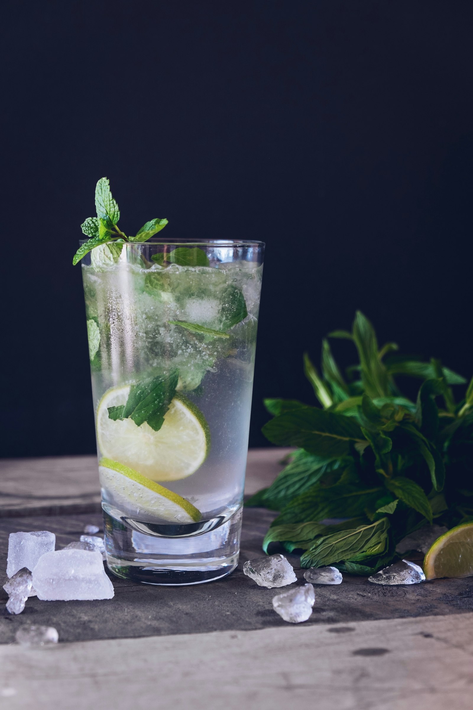 Tall mint-and-lime highball with ice and a bunch of fresh mint