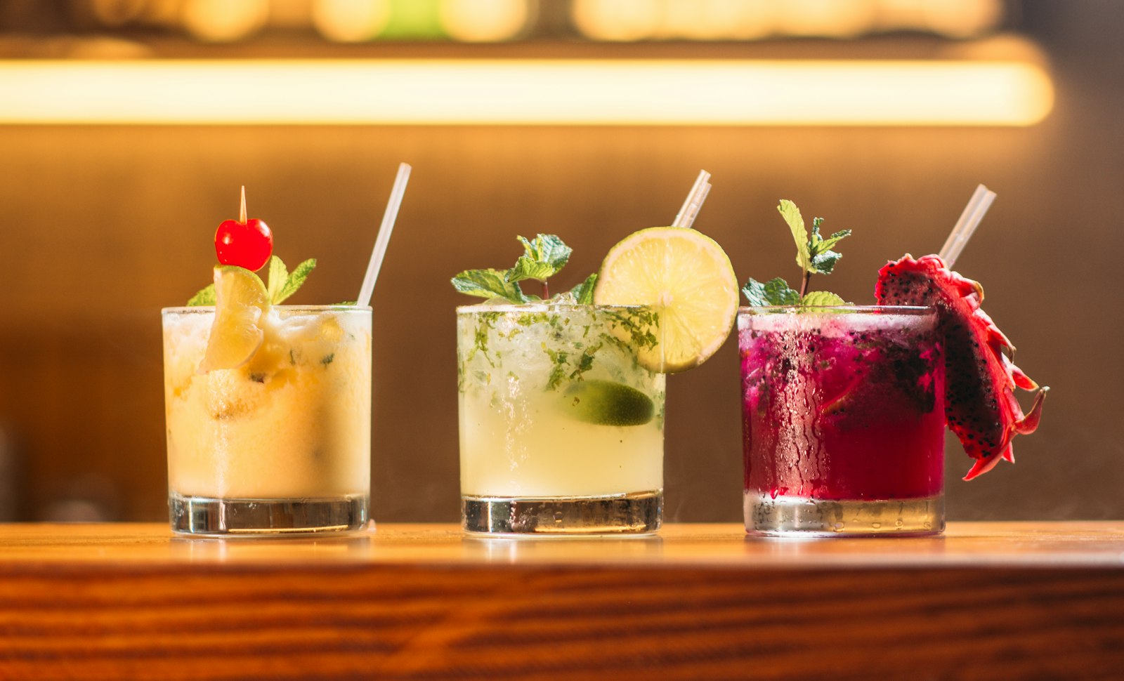 Three rocks cocktails — yellow, lime, and dragon-fruit red